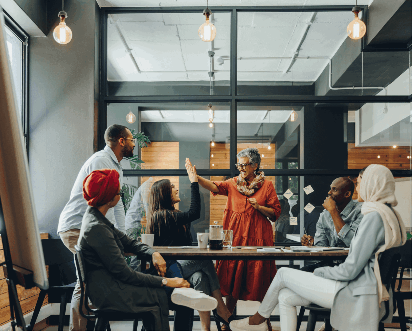 Team meeting with enthusiastic high-five exchange.