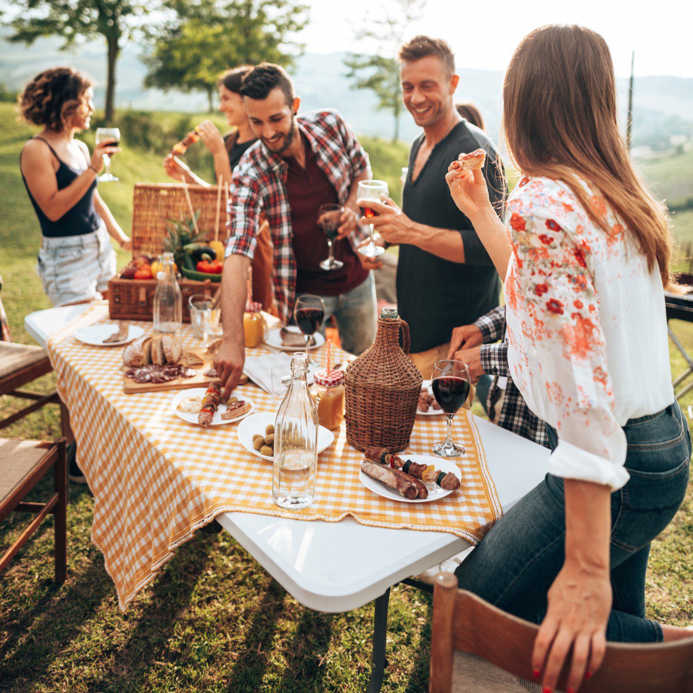 Group enjoying outdoor picnic with drinks.