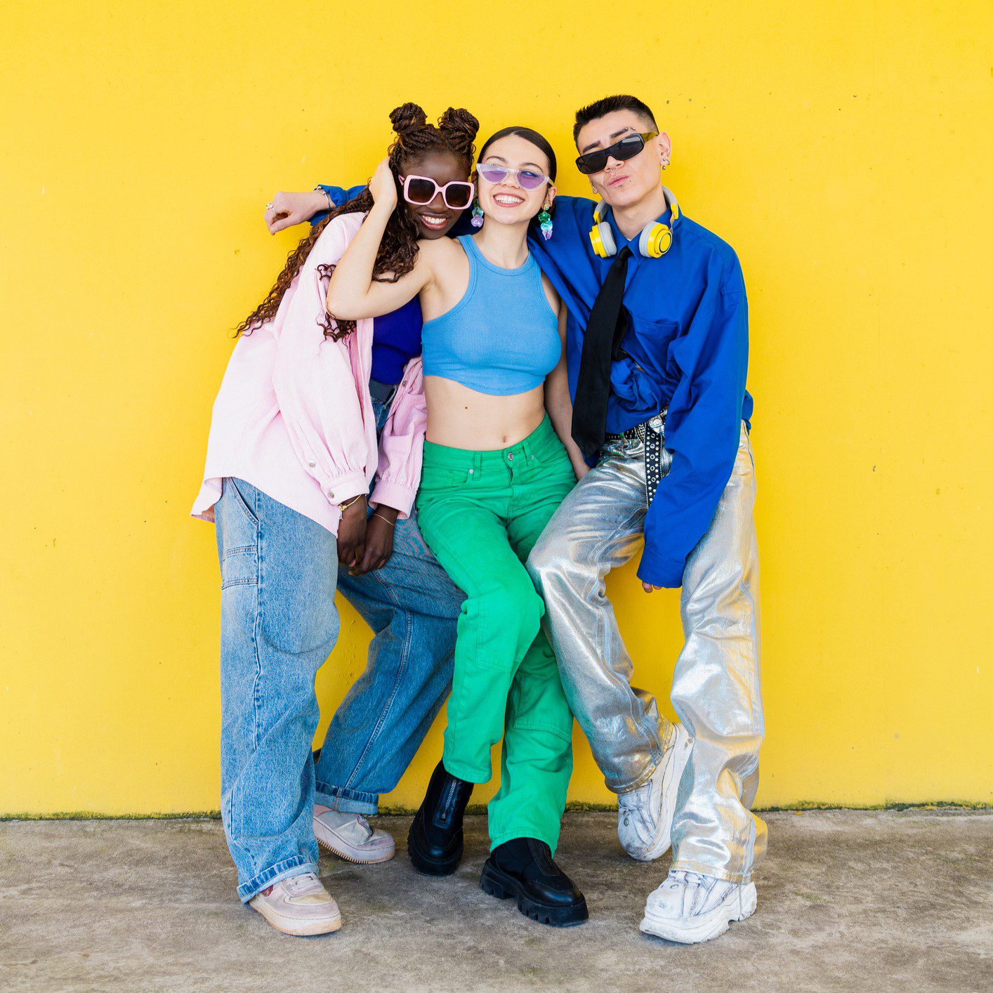 Group posing against bright yellow background.
