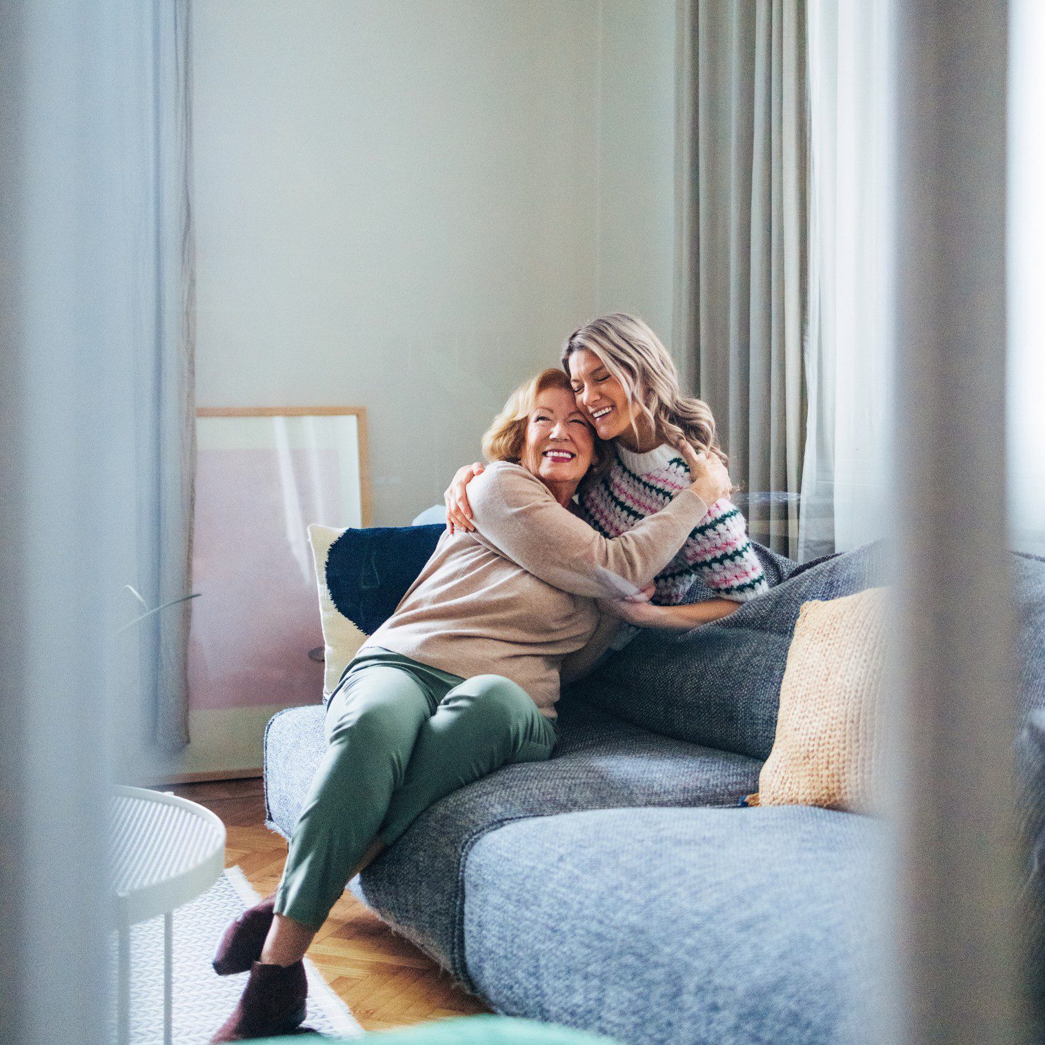 Two people hugging on a couch.