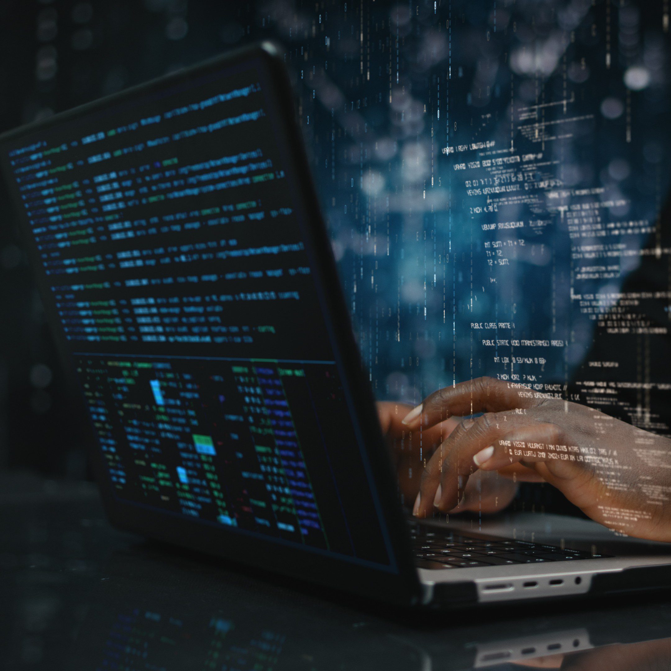 Hands typing on a laptop with code.