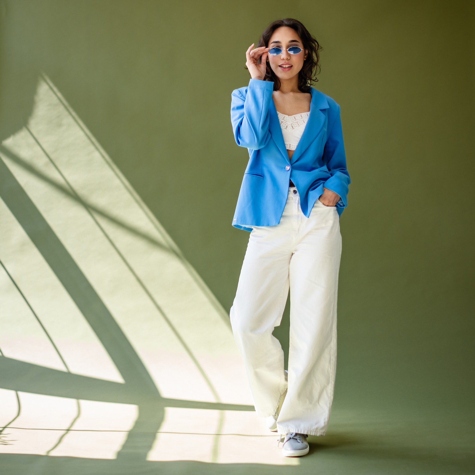 Woman in blue blazer and sunglasses.