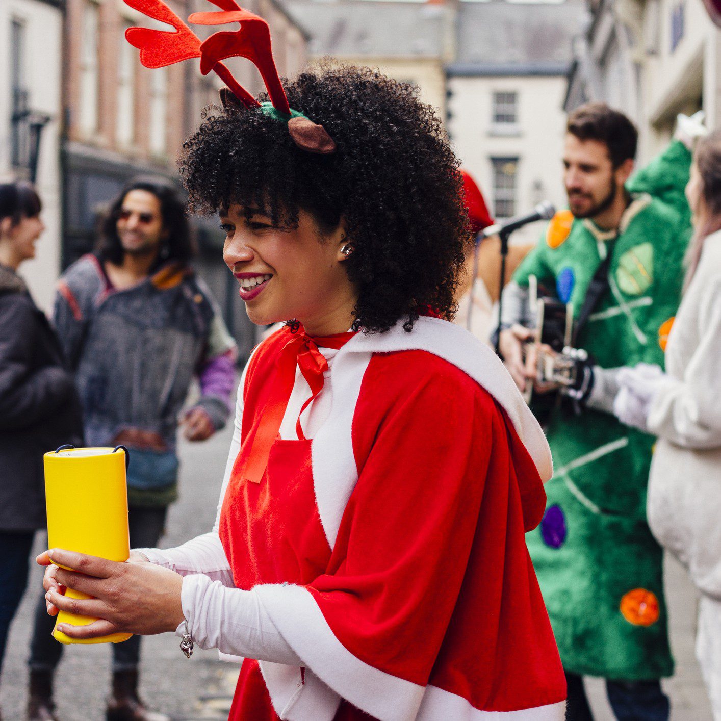 Person in festive costume collecting donations outside.
